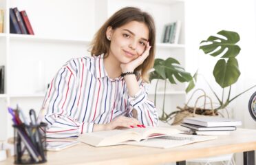 Female student sitting with book smiling 1